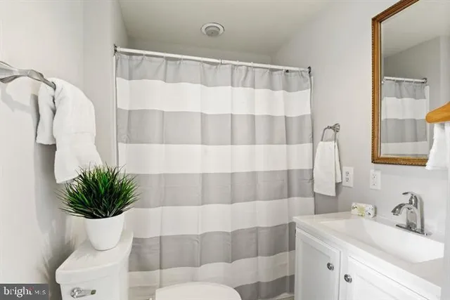 an empty room with windows and ceiling fan