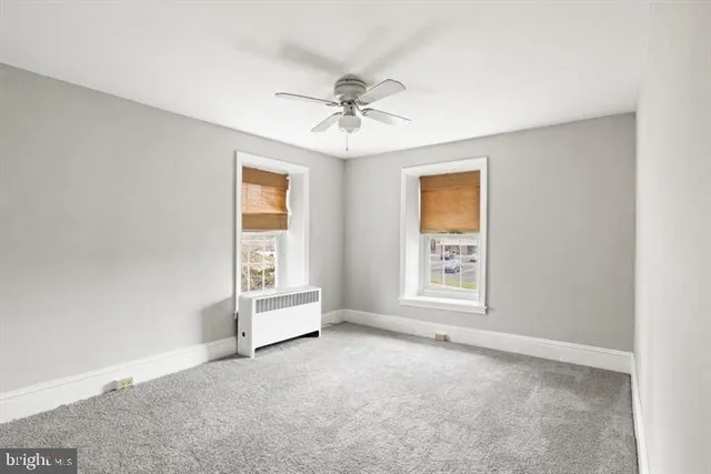 a view of an empty room and a ceiling fan
