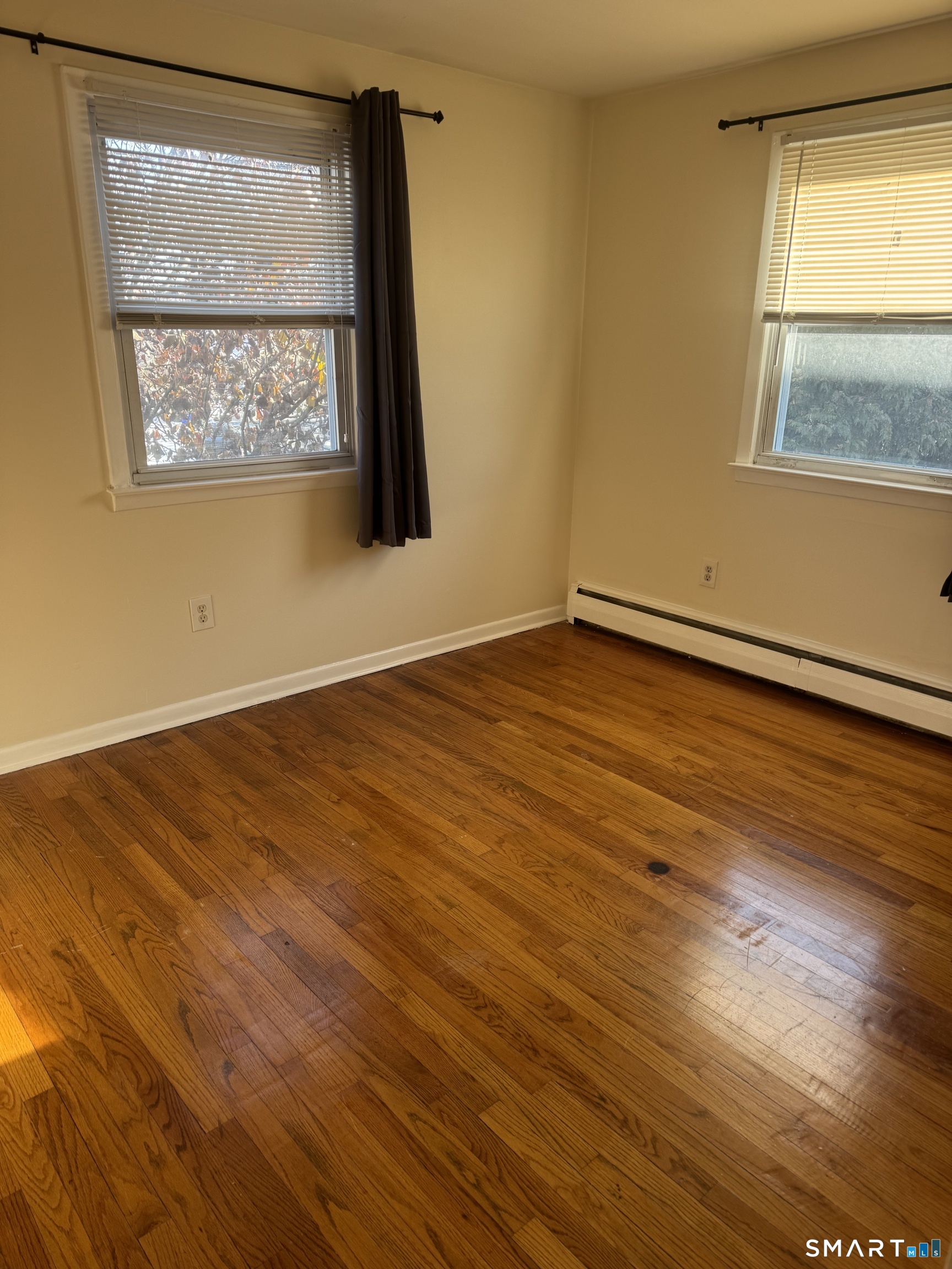 855 Black Rock Turnpike, Unit 1 Fairfield, CT 06825 - Photo 11 of 17 a view of an empty room with wooden floor and a window