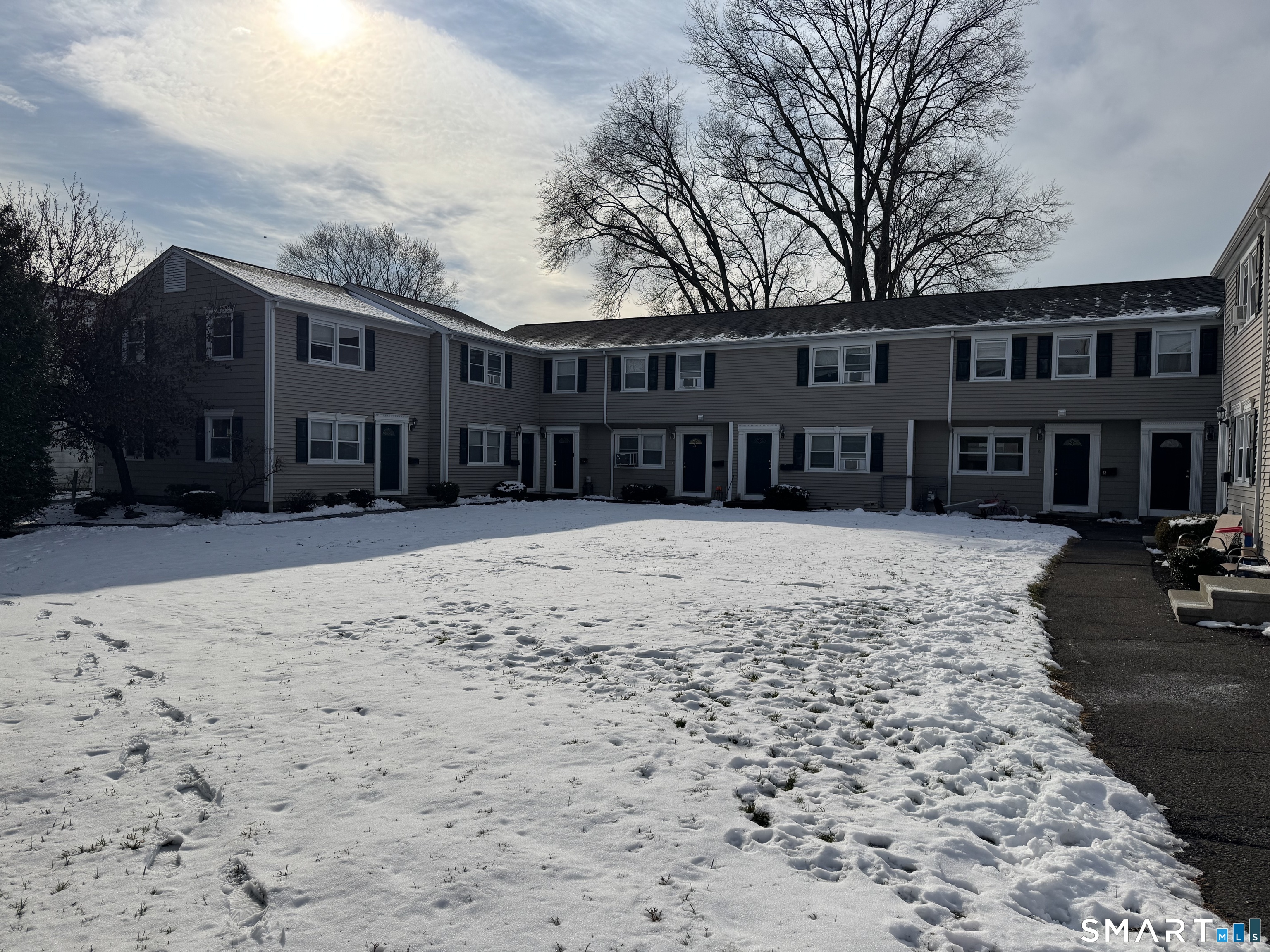 855 Black Rock Turnpike, Unit 1 Fairfield, CT 06825 - Photo 17 of 17 a view of a house with a yard covered in snow
