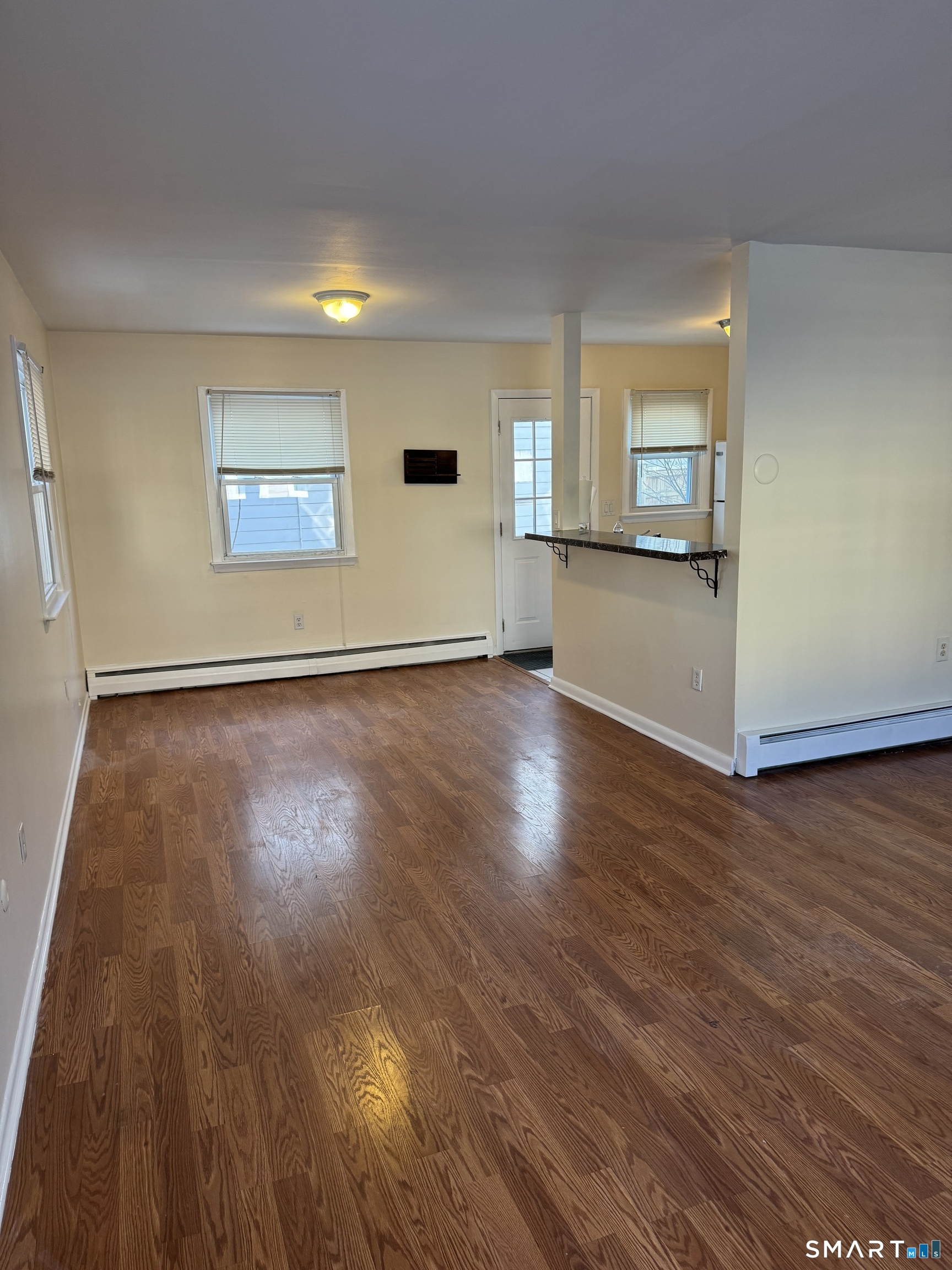 855 Black Rock Turnpike, Unit 1 Fairfield, CT 06825 - Photo 2 of 17 an empty room with wooden floor and windows