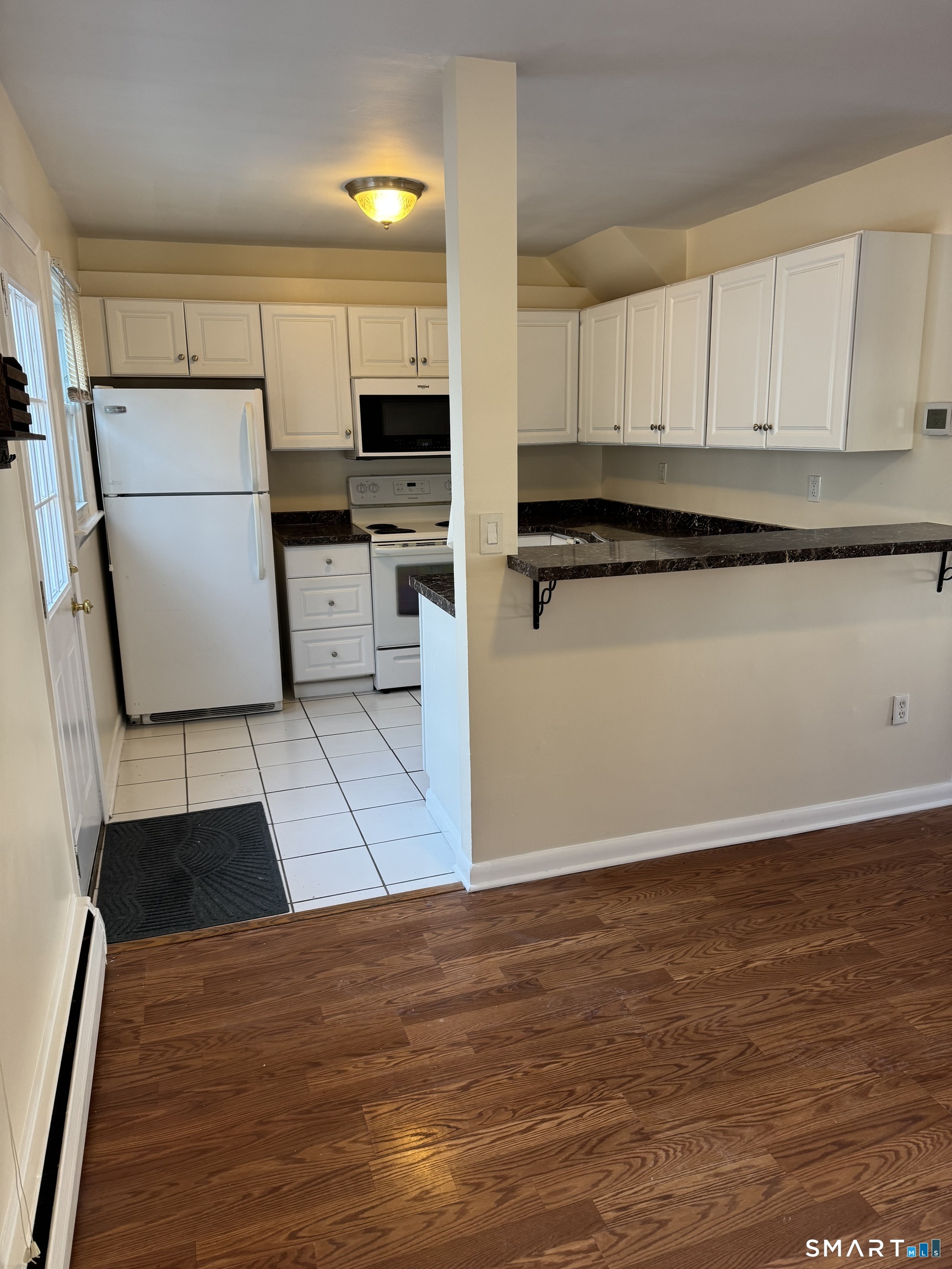 855 Black Rock Turnpike, Unit 1 Fairfield, CT 06825 - Photo 6 of 17 a kitchen with granite countertop a refrigerator and a stove top oven