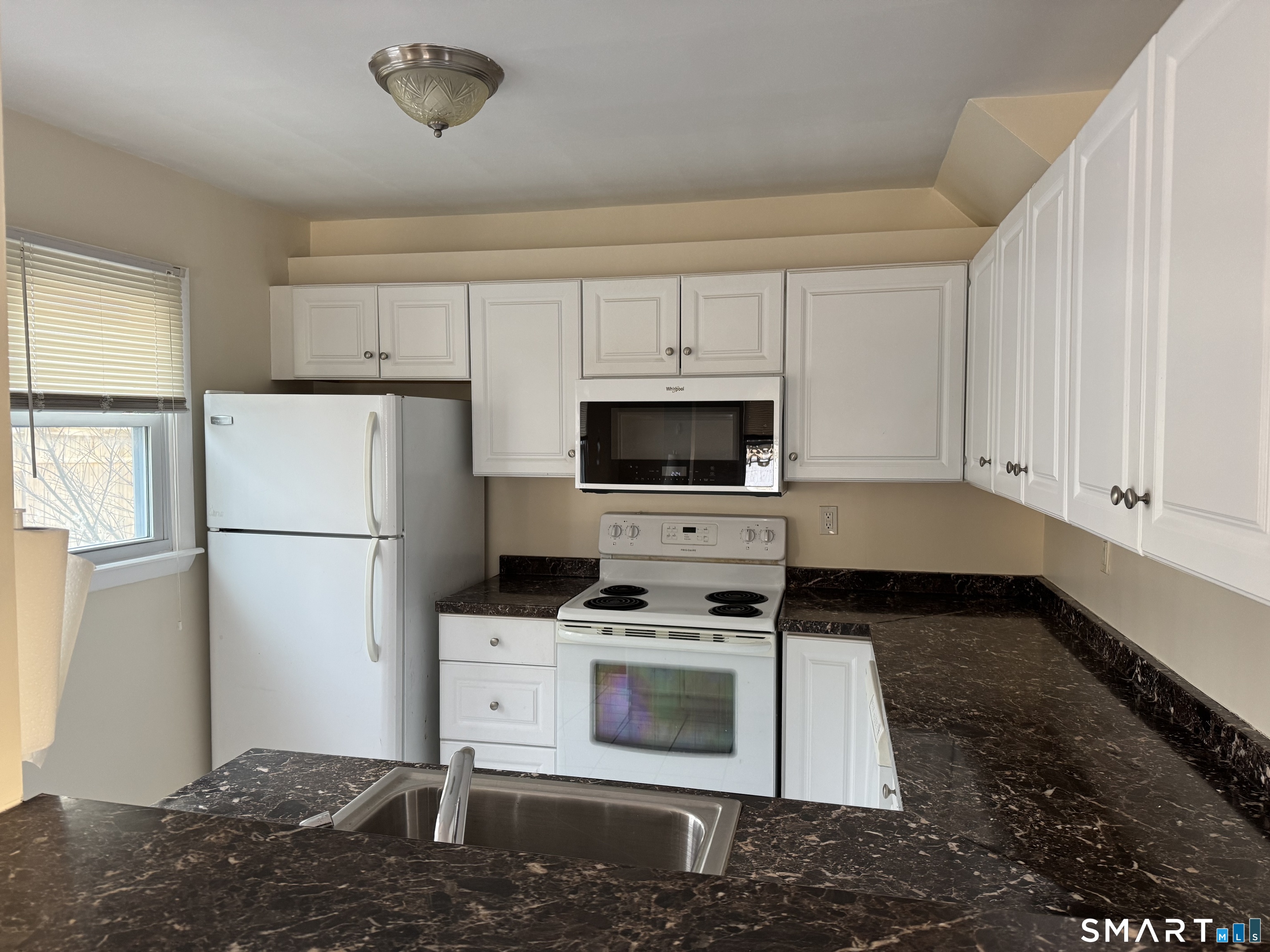 855 Black Rock Turnpike, Unit 1 Fairfield, CT 06825 - Photo 8 of 17 a kitchen with white cabinets and white appliances