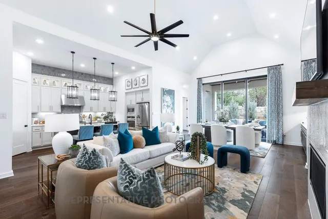 a living room with furniture kitchen view and a large window