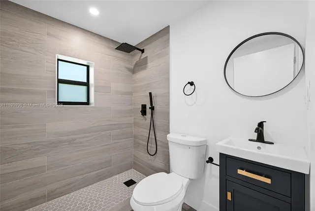 a bathroom with a toilet a sink and mirror