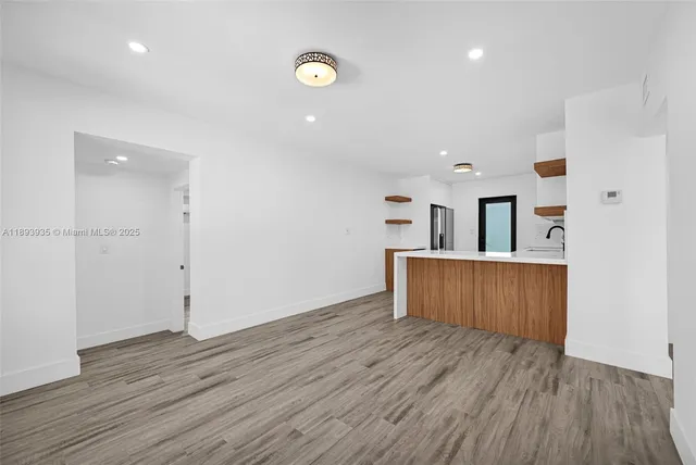 an empty room with wooden floor and mirror