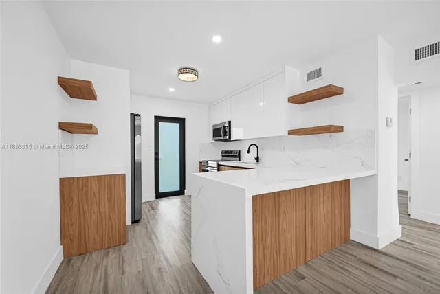 a view of kitchen with wooden floor and electronic appliances