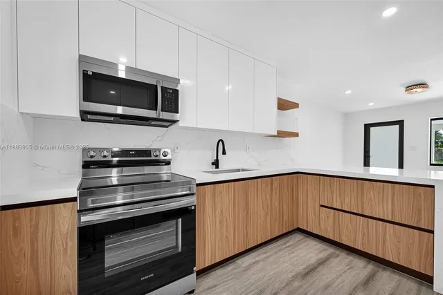a kitchen with stainless steel appliances a stove microwave and sink