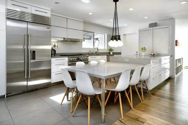 a kitchen with stainless steel appliances granite countertop a kitchen island a table and chairs