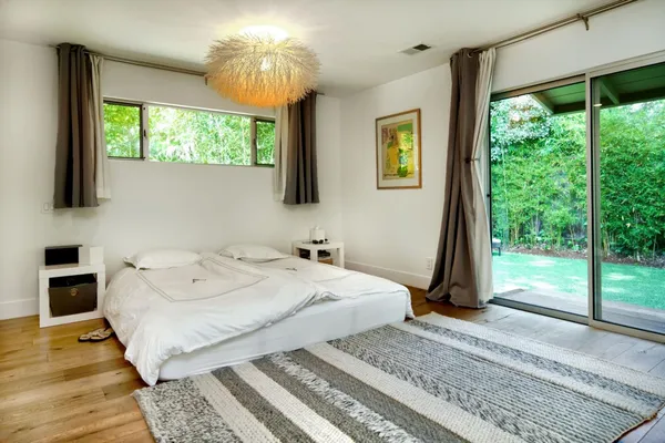 a spacious bedroom with a bed and a chandelier