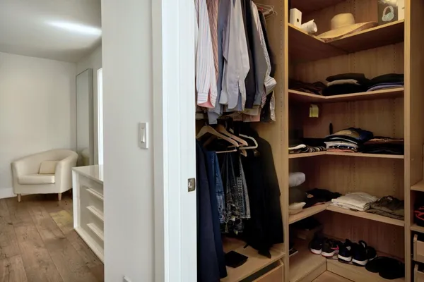 a view of walk in closet with clothes and shoes