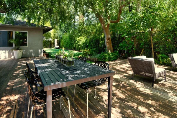 a view of backyard with outdoor seating and plants