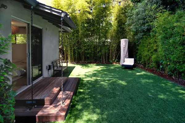a view of backyard with a table and chairs and potted plants