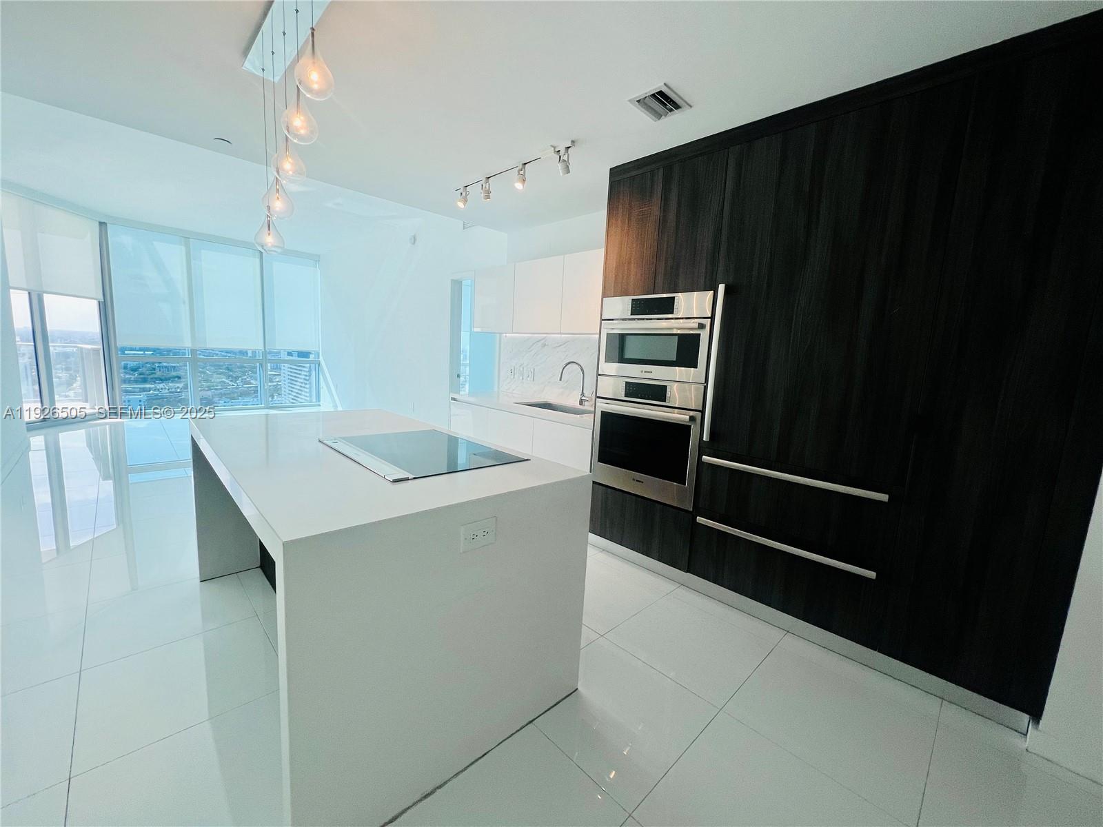 851 Northeast 1st Avenue, Unit 2808 Miami, FL 33132 - Photo 19 of 86 a kitchen with appliances and cabinets