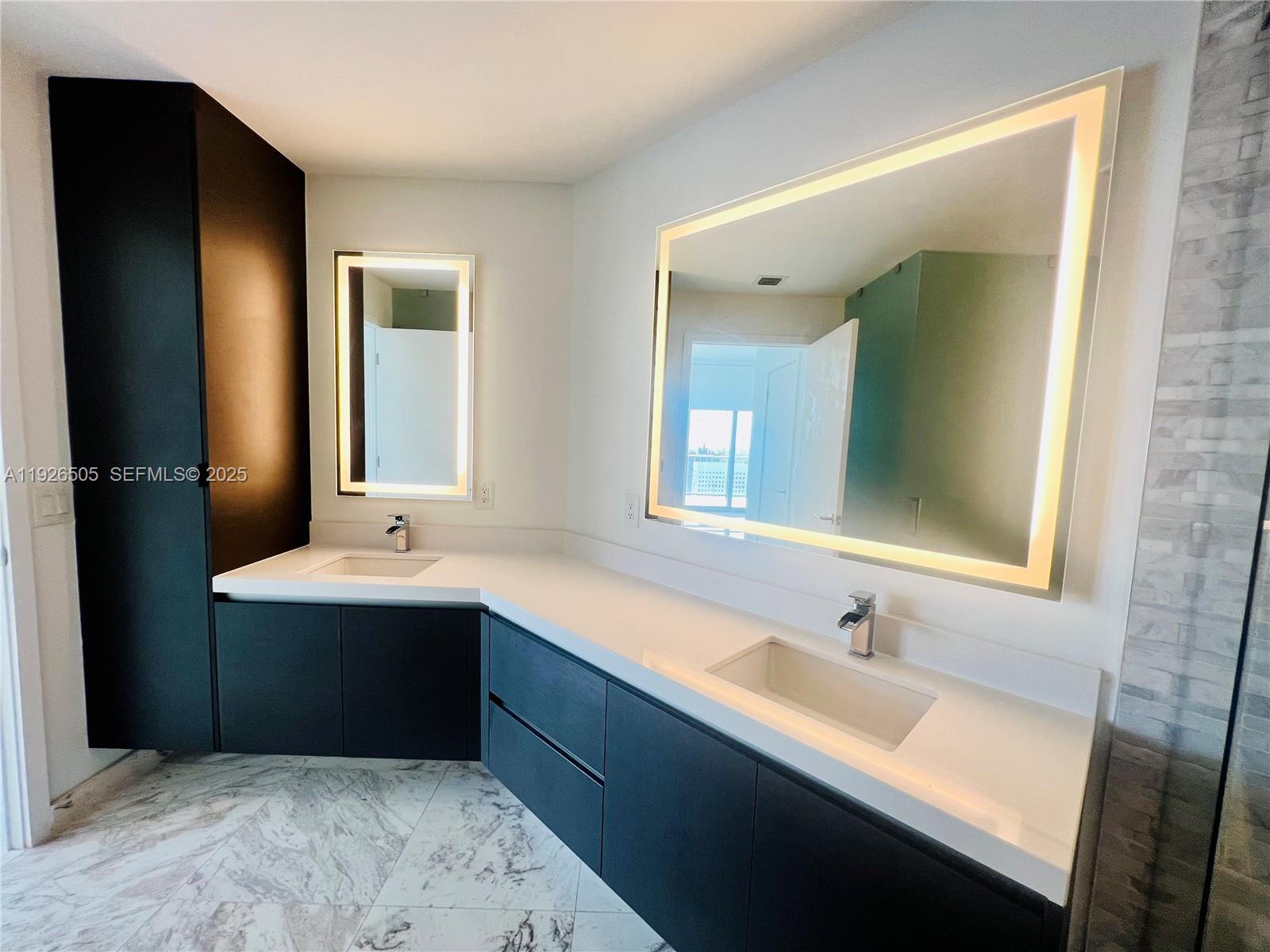 851 Northeast 1st Avenue, Unit 2808 Miami, FL 33132 - Photo 4 of 86 a bathroom with a sink and a mirror