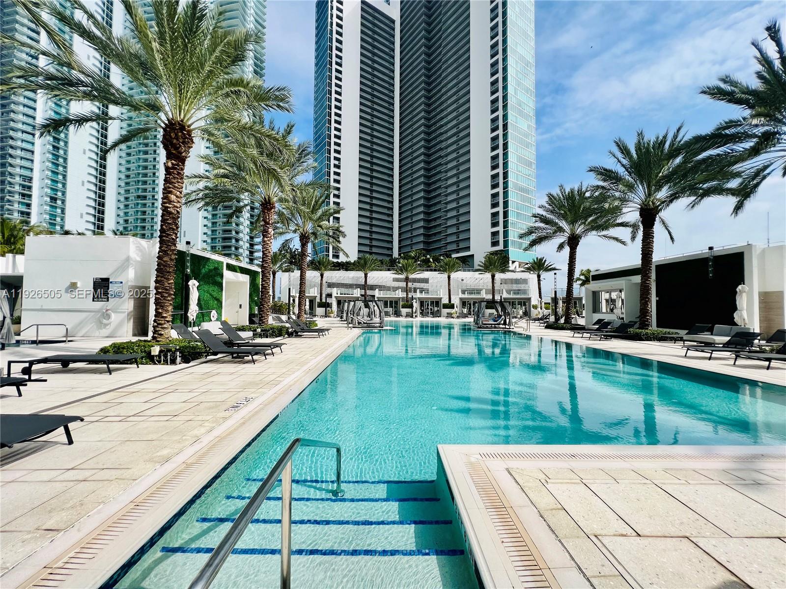 851 Northeast 1st Avenue, Unit 2808 Miami, FL 33132 - Photo 42 of 86 a swimming pool with outdoor seating and a garden