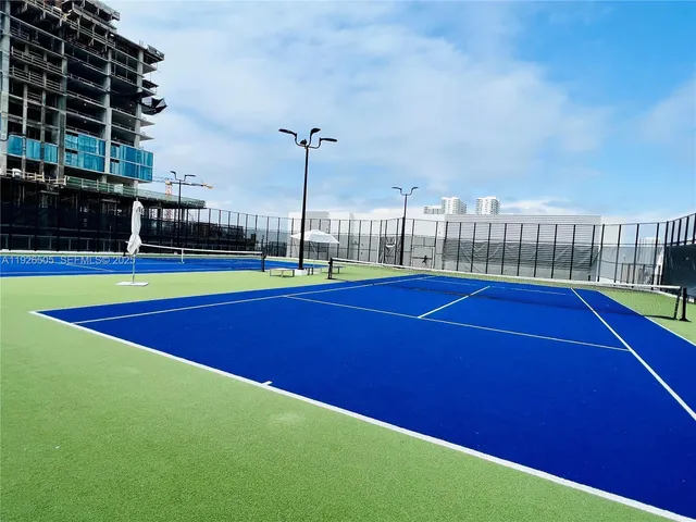 a large room with kitchen view and a wooden floor