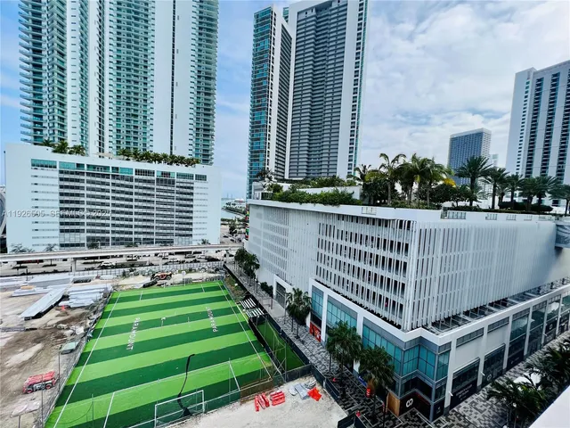 a view of kitchen with stainless steel appliances kitchen island granite countertop a sink and cabinets