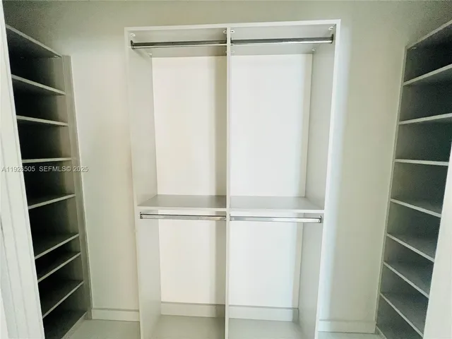 a view of walk in closet with empty racks