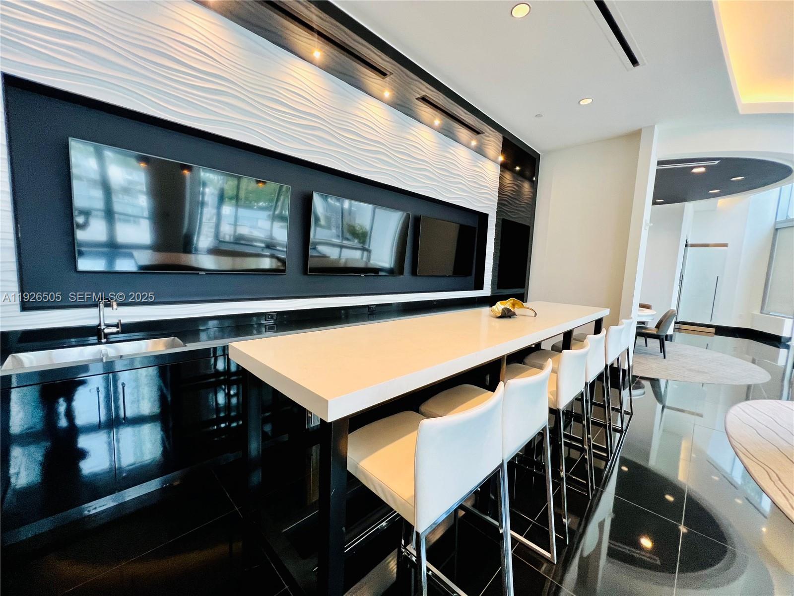 851 Northeast 1st Avenue, Unit 2808 Miami, FL 33132 - Photo 56 of 86 a kitchen with stainless steel appliances kitchen island granite countertop a stove top oven a sink a dining table and chairs with wooden floor