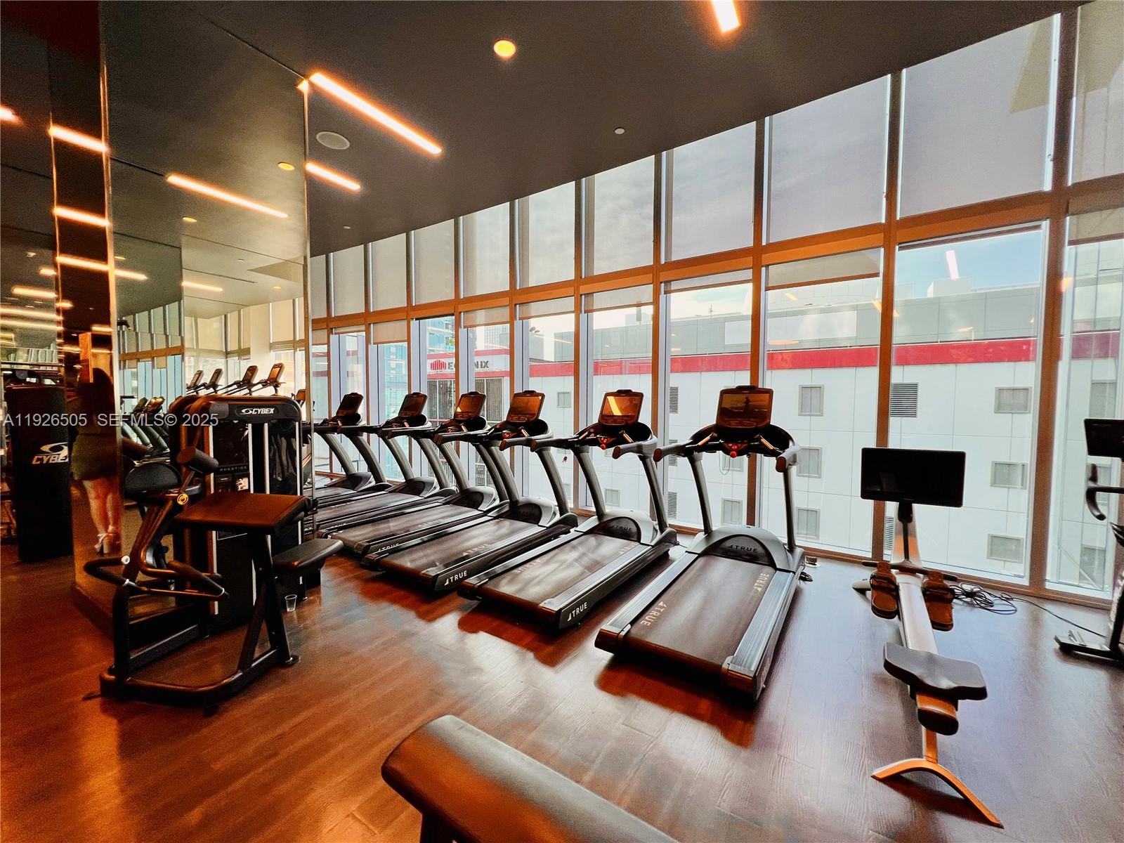 851 Northeast 1st Avenue, Unit 2808 Miami, FL 33132 - Photo 73 of 86 a view of a room with gym equipment and floor to ceiling window