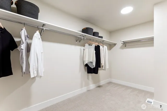 a view of walk in closet with clothes and shoes