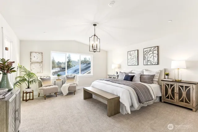 a spacious bedroom with a bed couch chandelier and a window