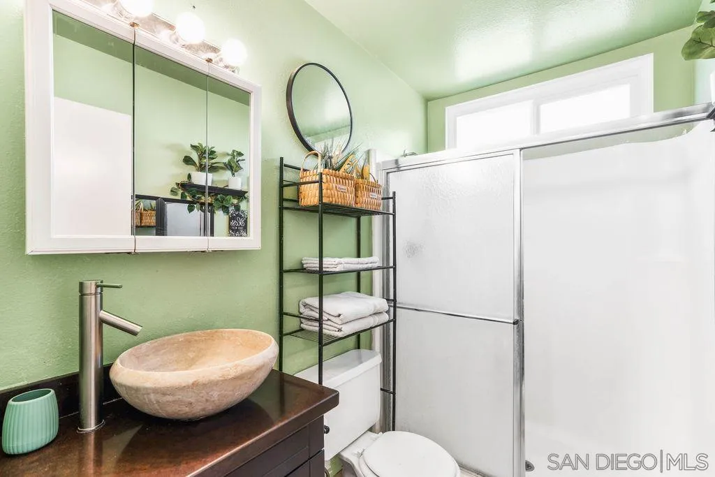 8659 Cordial Road El Cajon, CA 92021 - Photo 6 of 16 a bathroom with a toilet a sink and a mirror