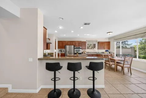 a kitchen with a dining table chairs and view living room