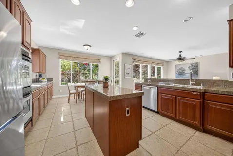 a kitchen with stainless steel appliances granite countertop a stove top oven a sink dishwasher and cabinets