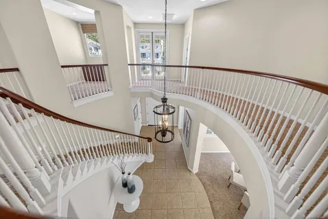 a living room with furniture flowers and a potted plant