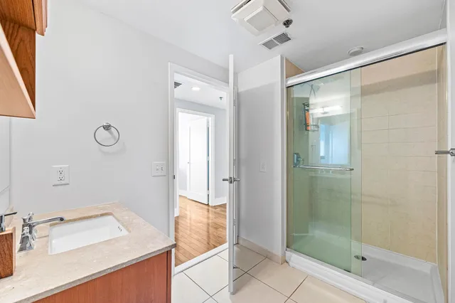 a bathroom with a sink shower and a mirror