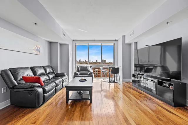a living room with furniture a flat screen tv and wooden floor