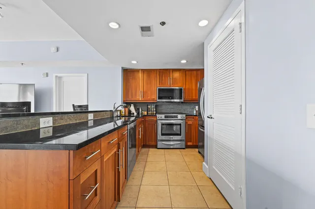 a large kitchen with stainless steel appliances granite countertop a sink and cabinets