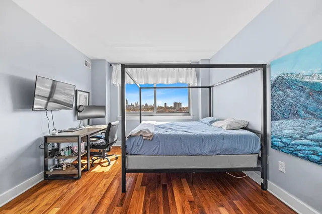a bedroom with a bed and wooden floor