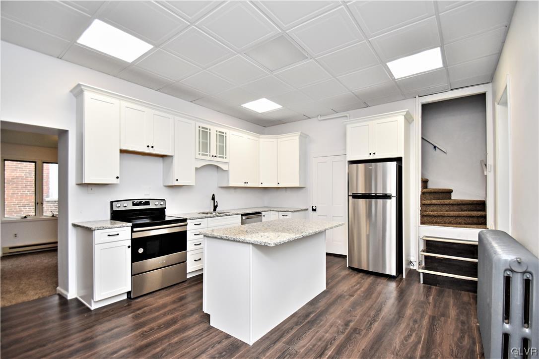 28 South 5th Street Emmaus, PA 18049 - Photo 8 of 23 a kitchen with granite countertop stainless steel appliances and wooden cabinets