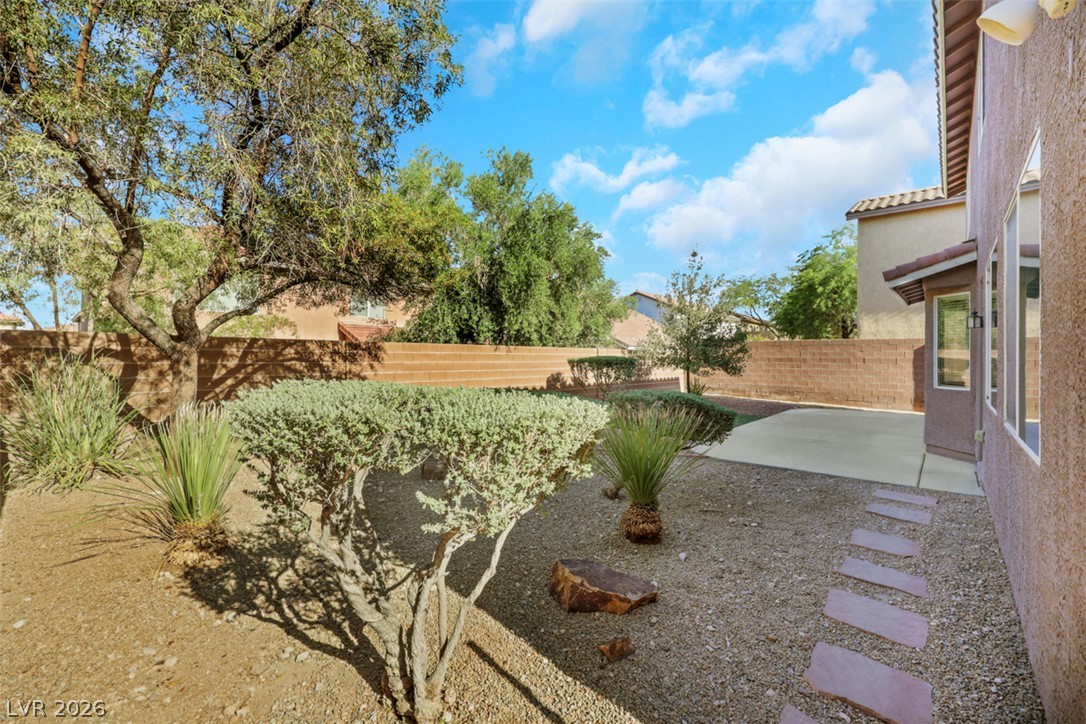 10328 Hawk Ravine Street Las Vegas, NV 89178 - Photo 45 of 55 An inviting backyard oasis awaits with a spacious patio, mature trees, and a privacy wall.