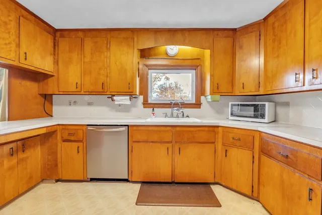a kitchen with granite countertop cabinets and large window