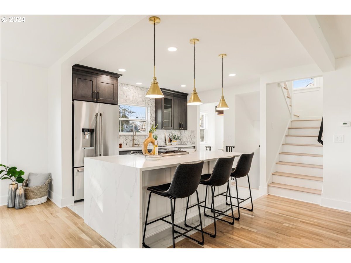 2639 North Sumner Street Portland, OR 97217 - Photo 12 of 46 a kitchen with stainless steel appliances kitchen island granite countertop a table chairs and a refrigerator