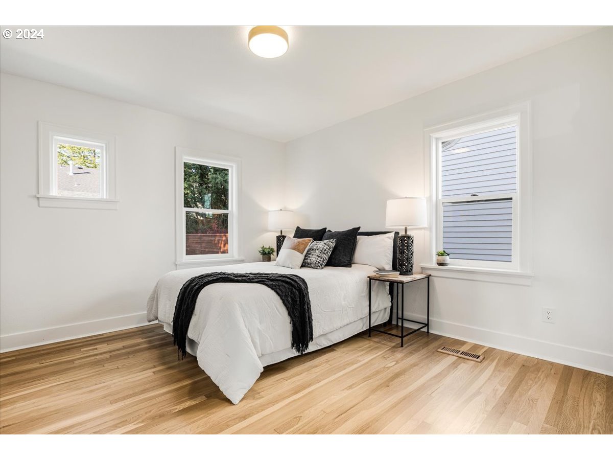 2639 North Sumner Street Portland, OR 97217 - Photo 19 of 46 a bedroom with a bed and wooden floor