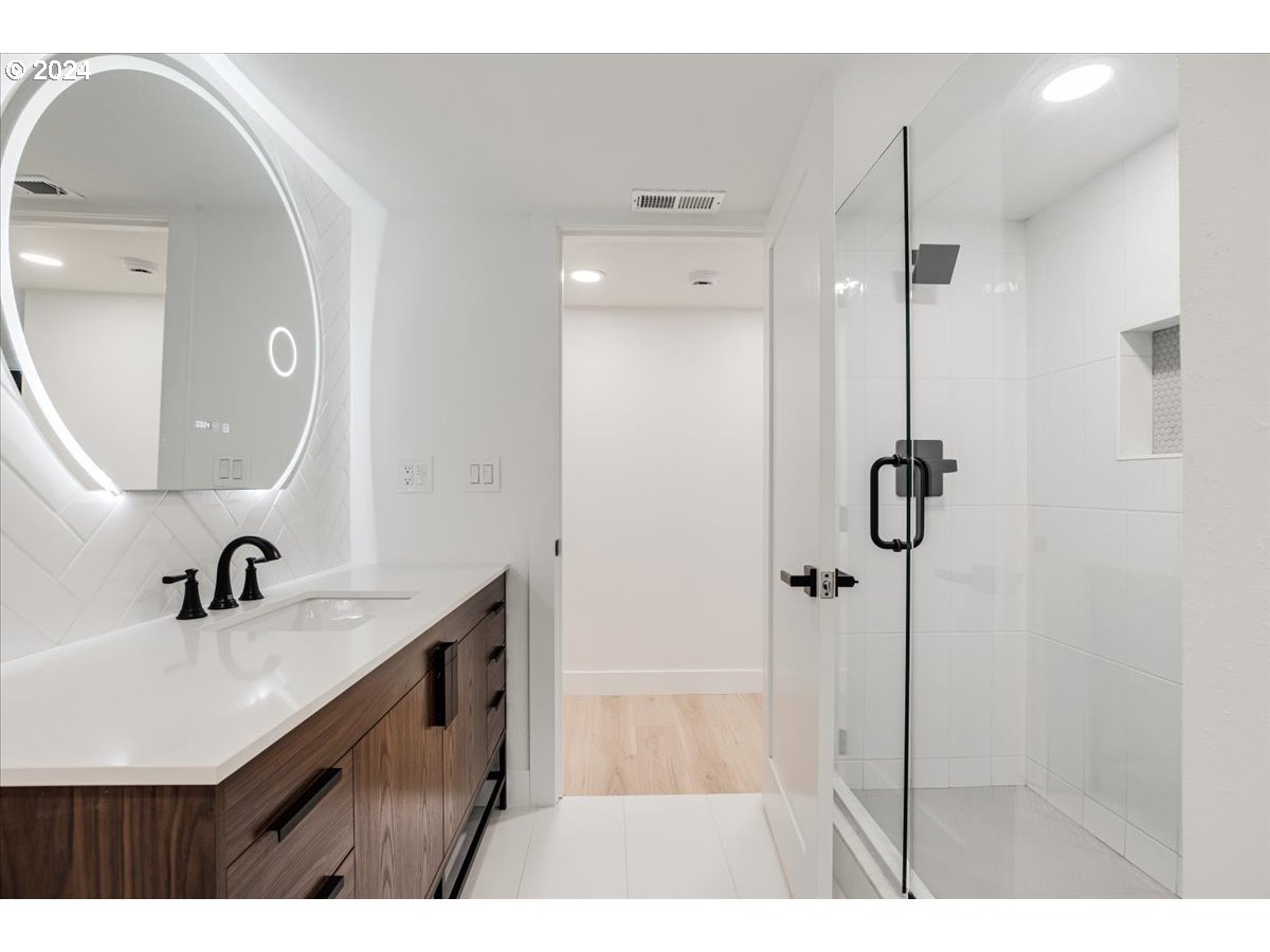 2639 North Sumner Street Portland, OR 97217 - Photo 35 of 46 a bathroom with a sink a mirror a vanity and shower