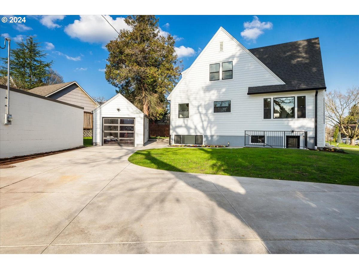 2639 North Sumner Street Portland, OR 97217 - Photo 40 of 46 a view of a white house next to a yard with big trees