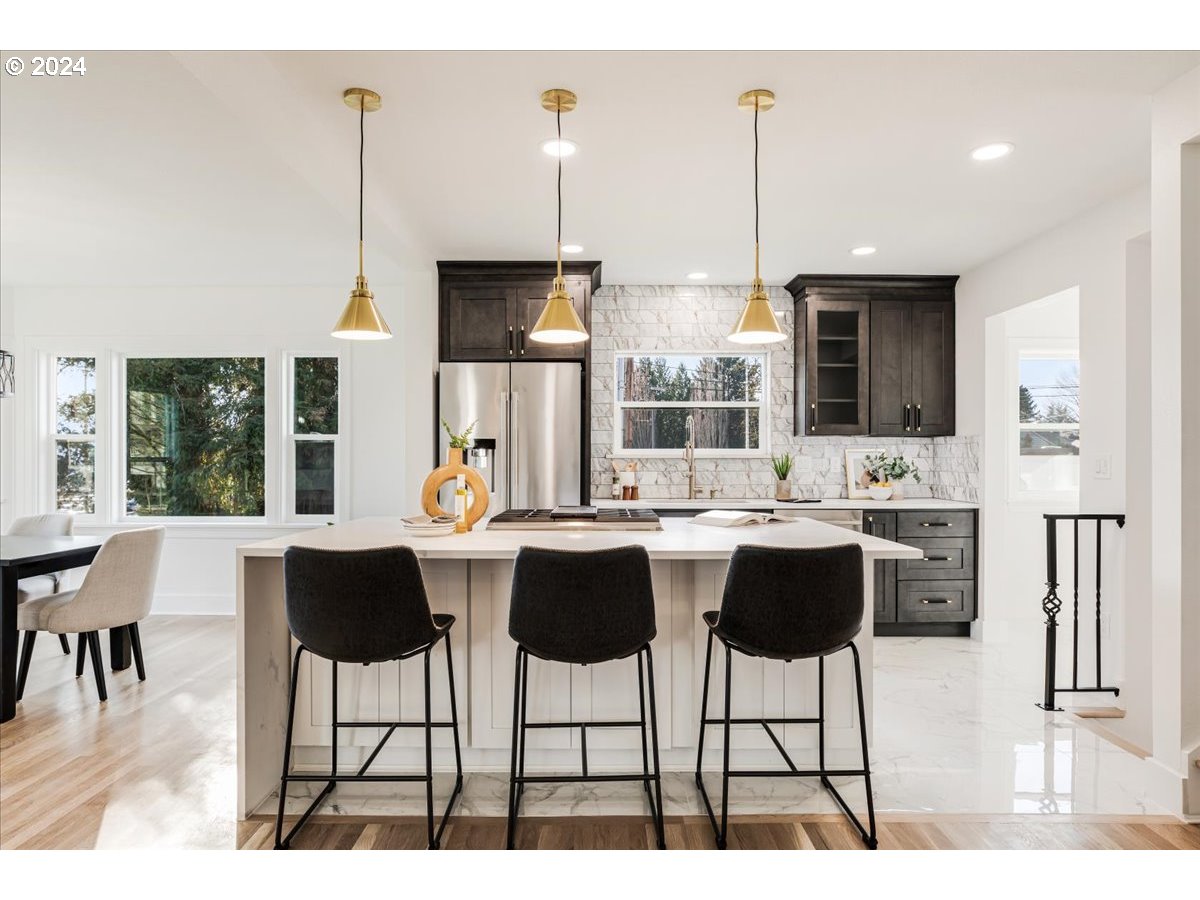 2639 North Sumner Street Portland, OR 97217 - Photo 6 of 46 a kitchen with stainless steel appliances kitchen island granite countertop a dining table chairs and granite counter tops