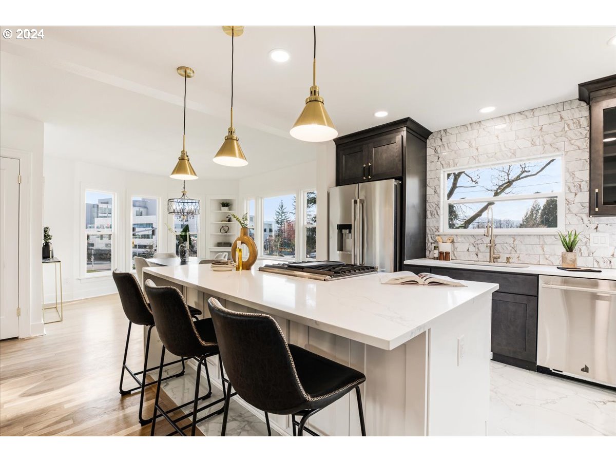 2639 North Sumner Street Portland, OR 97217 - Photo 7 of 46 a kitchen with stainless steel appliances kitchen island granite countertop a table chairs stove and refrigerator