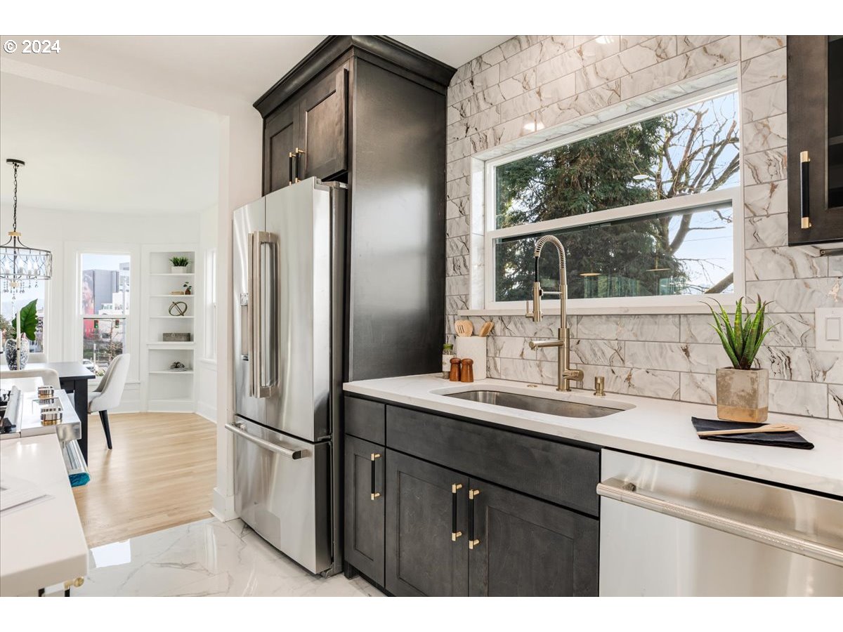 2639 North Sumner Street Portland, OR 97217 - Photo 10 of 46 a kitchen with kitchen island a counter top space and a refrigerator