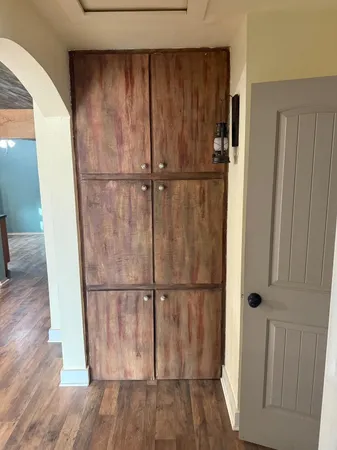 a walk in closet with wooden floor