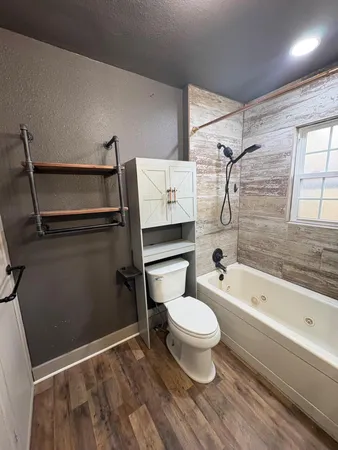 a bathroom with a tub sink and mirror