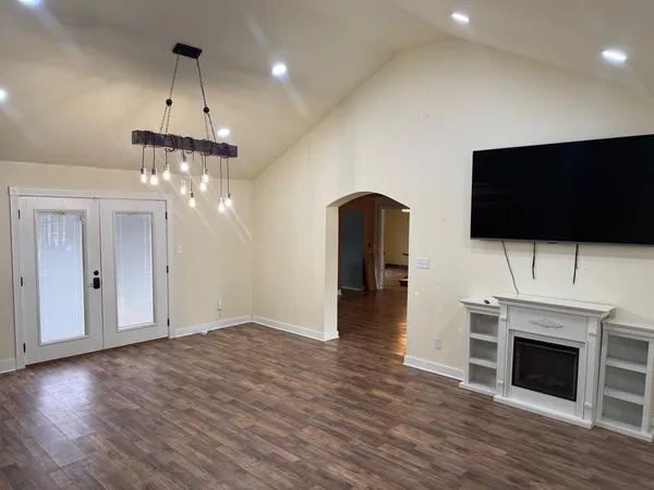 a view of a livingroom with a fireplace a flat screen tv and staircase