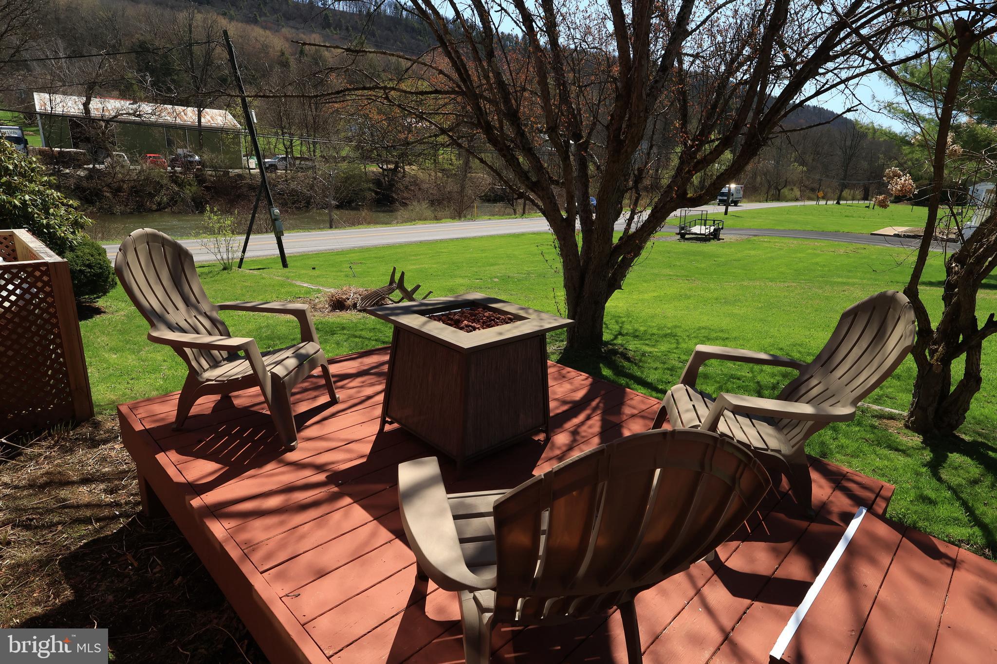 1343 Penns Creek Road Coburn, PA 16832 - Photo 44 of 92 a view of a patio with table and chairs under an umbrella with large trees