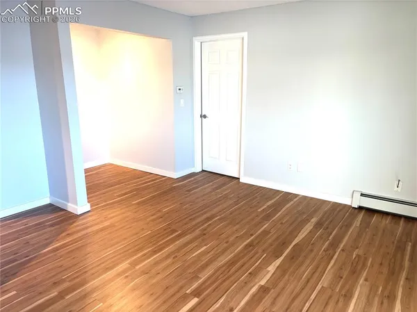 an empty room with wooden floor and sliding door